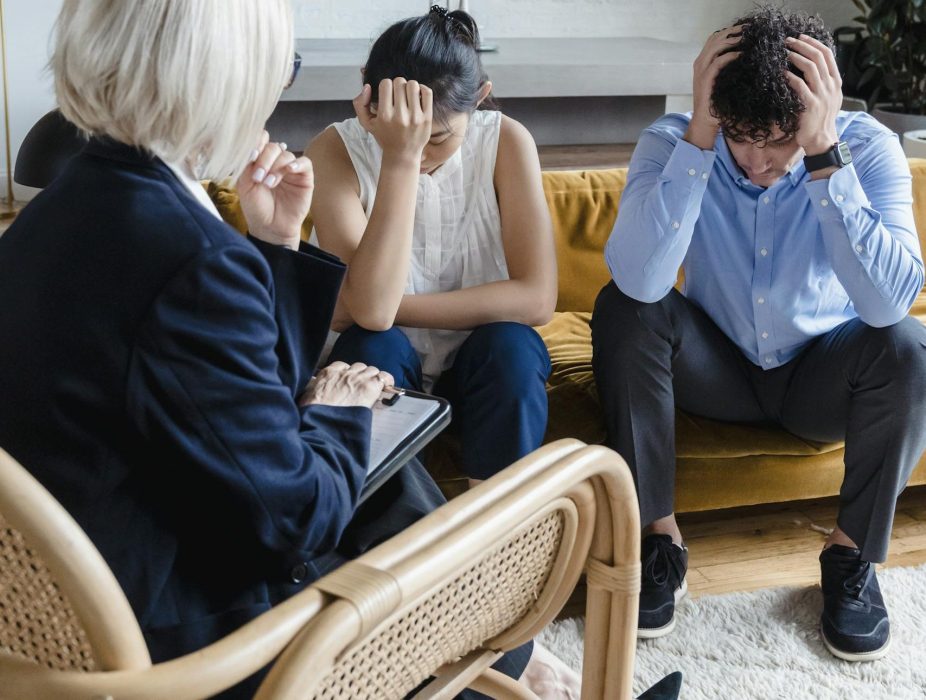 couple-in-therapy-session-showing-distress-guided-by-a-therapist.-8560652-scaled-e1786754687380